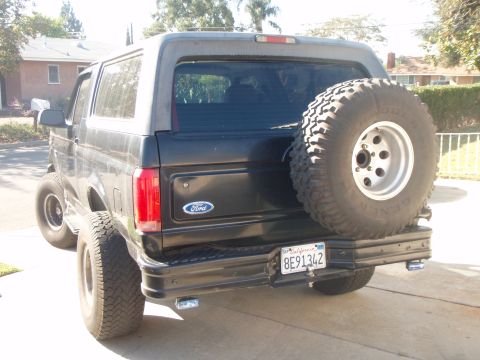1995 Ford Bronco - Rear view of a black Ford Bronco, a spare tire mounted on the tailgate and a California license plate.