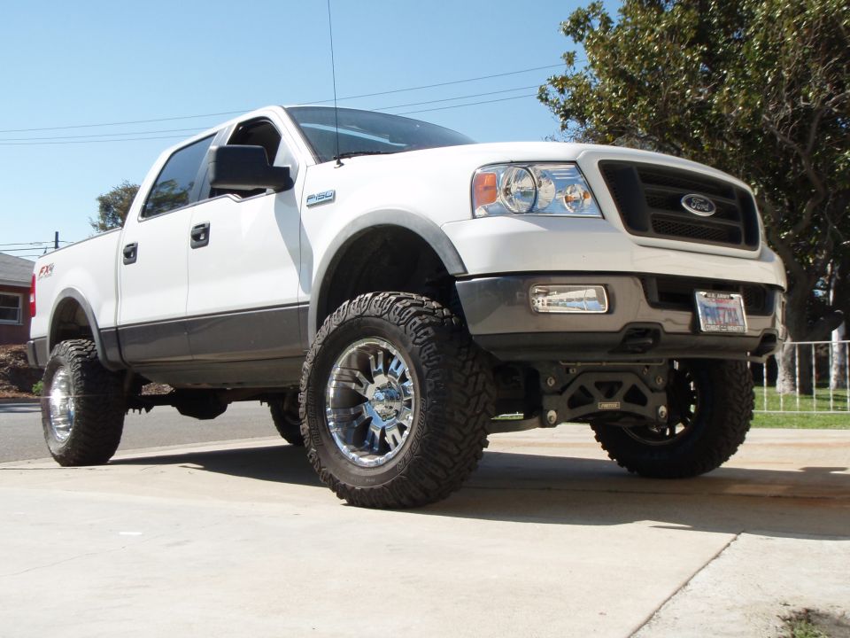 Lifted 2005 Ford F-150 pickup truck with aftermarket wheels and tires