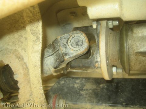 1987 Suzuki Samurai - Close-up view of a vehicle's driveshaft connection, showing a U-joint and flange.