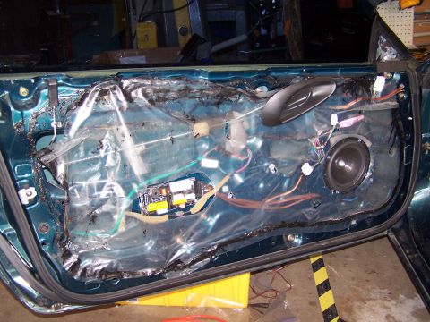 1996 Ford Probe - The interior of a car door is exposed, revealing the speaker and various electrical components.