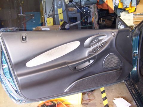 1996 Ford Probe - The interior door panel of a 1996 Ford Probe shows gray fabric and power controls.