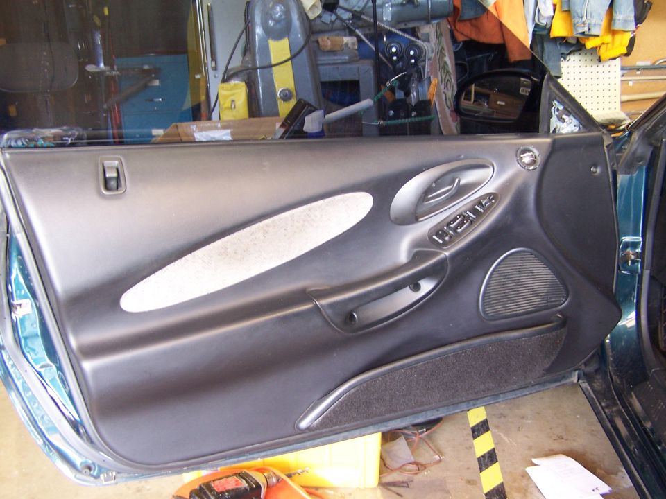 1996 Ford Probe interior door panel with gray fabric insert and power window controls