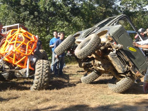 1989 Ford Bronco - An off-road vehicle is tipped on its side while another custom buggy sits nearby.