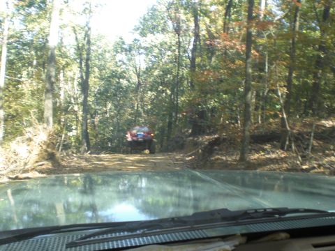 1989 Ford Bronco - Two vehicles navigate a wooded path, with one seen from the perspective of the other.