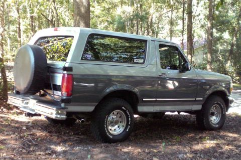 1996 Ford Bronco - A 1996 Ford Bronco is parked outdoors with trees in the background.