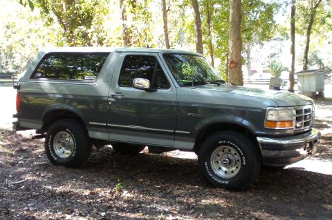 1996 Ford Bronco - This 1996 Ford Bronco is shown from a three-quarter front view, parked in a wooded area.