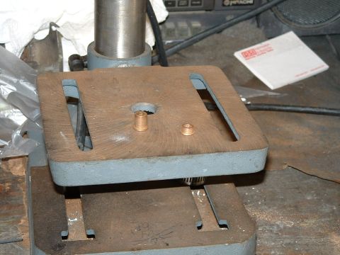 1978 Ford Ranchero - A close-up view of a drill press table with two brass bushings on its surface.