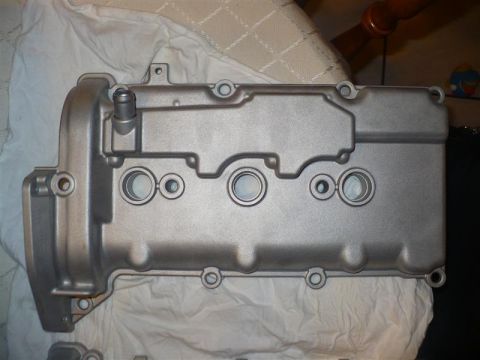 1993 Ford Probe - Engine valve cover with three spark plug holes visible, resting on a white cloth.