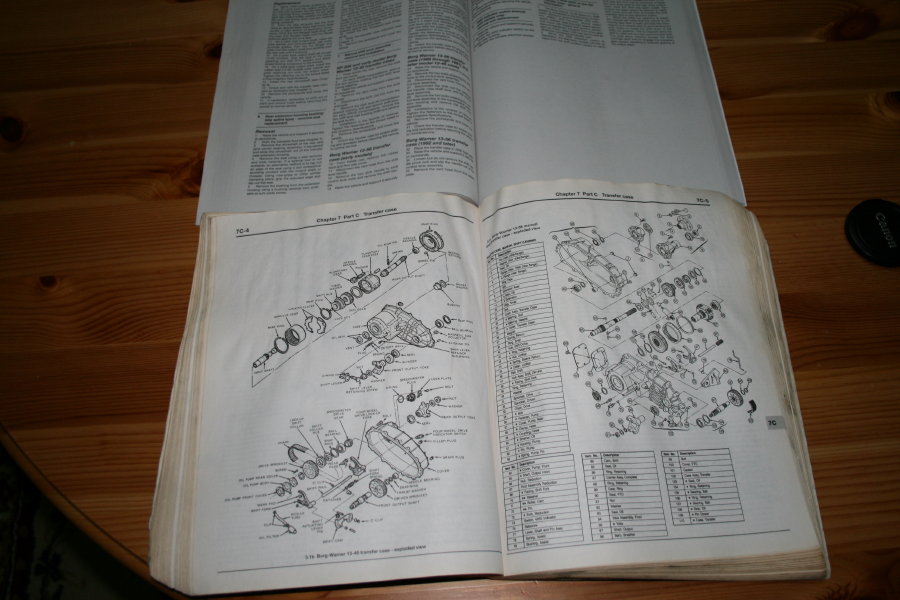 Repair manual open to transfer case exploded view diagrams with numbered parts list