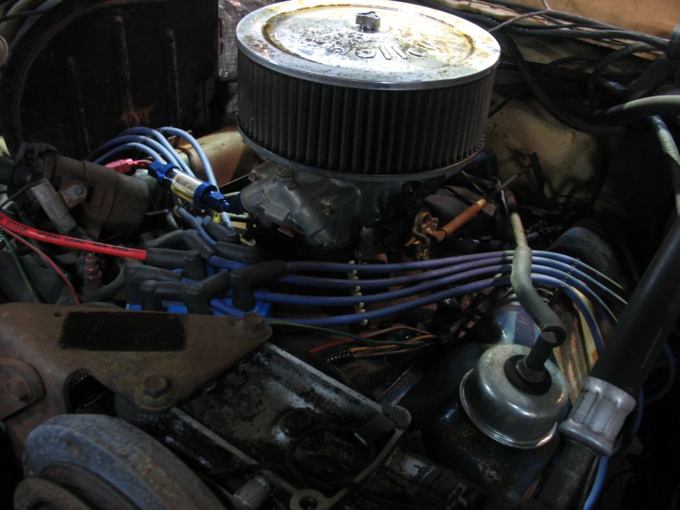 Engine bay showing air cleaner, carburetor, spark plug wires, and fuel filter