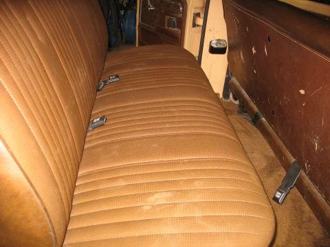 1978 Ford F-250 - Interior view of a vehicle's bench seat, showing the brown upholstery and seatbelts.