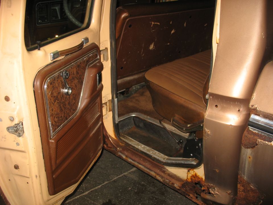 Interior of a 1978 Ford F-250 showing tan door panel with woodgrain insert and brown seat