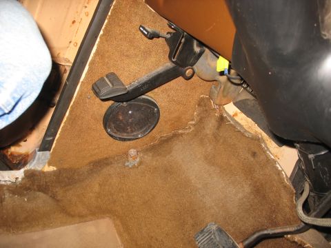1978 Ford F-250 - The interior floorboard of a 1978 Ford F-250 shows worn brown carpet and the brake and clutch pedals.