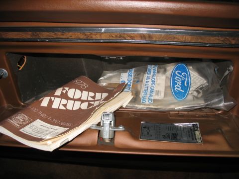 1978 Ford F-250 - The glove compartment contains a 1978 Ford Truck owner's manual and a bag of Ford parts.