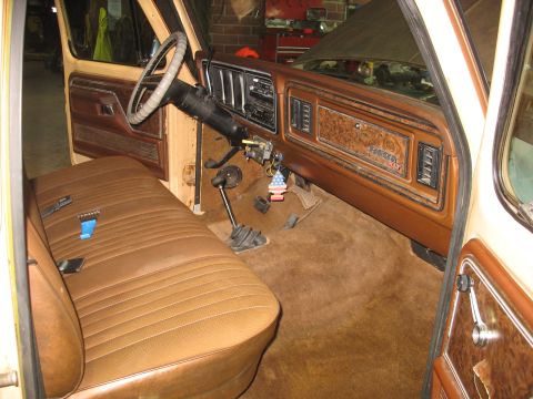 1978 Ford F-250 - The interior of a 1978 Ford F-250 pickup truck, a bench seat and wood-grain dashboard trim.