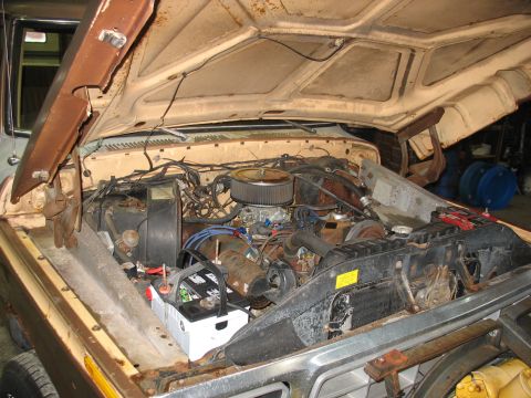 1978 Ford F-250 - The engine bay of a 1978 Ford F-250 pickup truck, showing the V8 engine, carburetor, and battery.