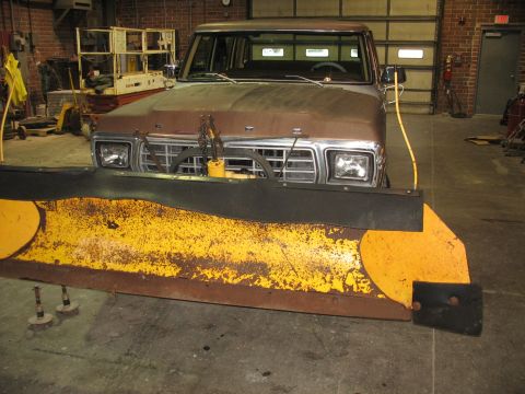 1978 Ford F-250 - A weathered Ford pickup truck is parked indoors, equipped with a heavy-duty snow plow.