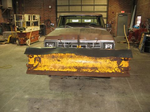 1978 Ford F-250 - A weathered Ford truck equipped with a snow plow sits in a workshop.