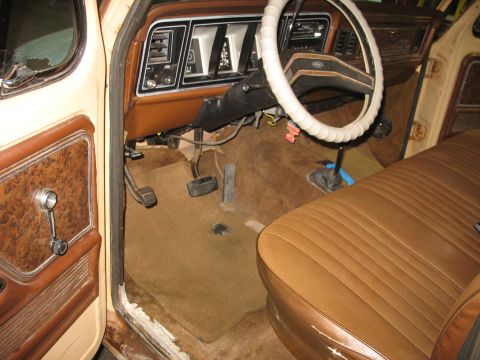 1978 Ford F-250 - The interior of a 1978 Ford F-250 pickup truck, brown upholstery and wood-grain trim on the door panel.