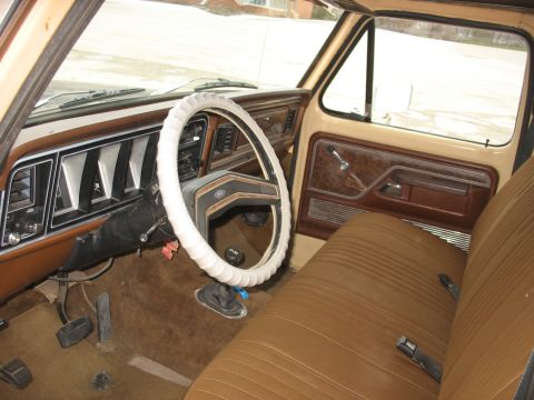 1978 Ford F-250 - The interior of a 1978 Ford F-250 pickup truck features brown upholstery and a tan dashboard.