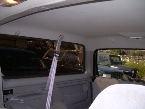 1986 Ford Bronco - The interior of a 1992 Ford Bronco reveals a view of other vehicles parked outside.