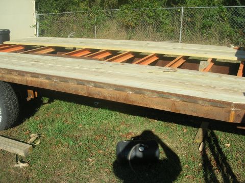 1991 Ford F-150 - A gooseneck trailer is shown with a wooden deck and exposed metal framing, resting on grass.