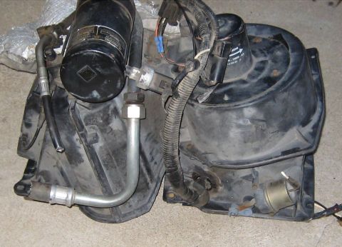 1996 Ford Bronco - HVAC blower motor assembly, likely for a vehicle, with visible hoses and electrical connections.