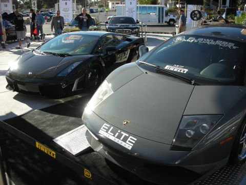 1998 Ford Crown Victoria - Two Lamborghinis are on display, one grey and one black, with various stickers on their windshields.