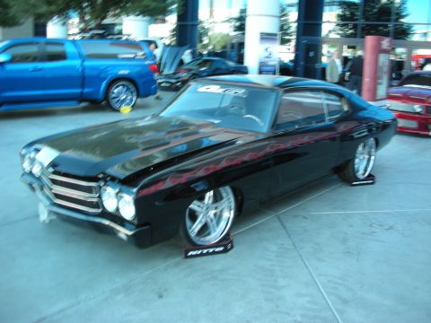 1998 Ford Crown Victoria - Customized black coupe with flame graphics and large chrome wheels, displayed at an event.