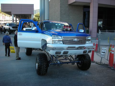 1998 Ford Crown Victoria - A heavily modified pickup truck is displayed with its doors open, custom modifications and a lifted suspension.