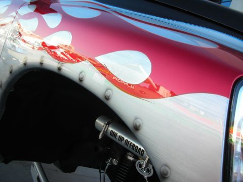 1998 Ford Crown Victoria - A close-up of a customized vehicle fender shows flame graphics and an "ONE UP OFFROAD" exhaust pipe.