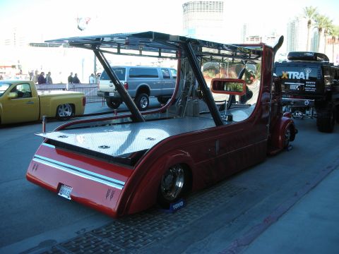 1998 Ford Crown Victoria - A custom-built red tow truck is parked on a street, with other vehicles visible in the background.