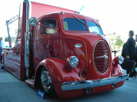 1998 Ford Crown Victoria - This custom semi-truck features a vibrant red paint job with flame graphics and prominent chrome exhaust pipes.