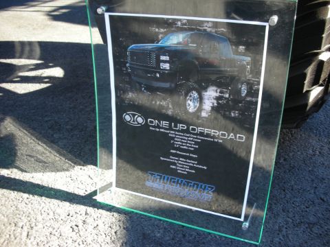 1998 Ford Crown Victoria - A custom lifted truck is showcased on a display board with details about its off-road conversion.