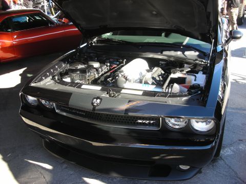 1998 Ford Crown Victoria - Front view of a black Dodge Challenger SRT with the hood open, revealing the engine bay. Another car is visible behind it.