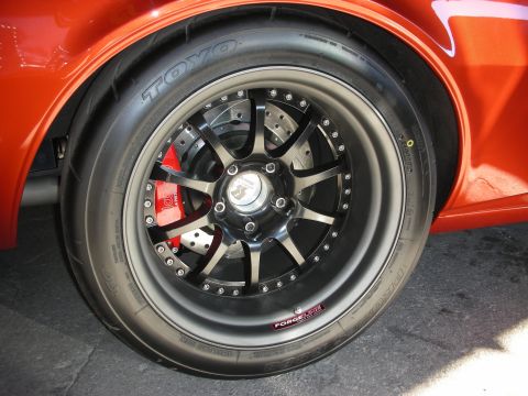 1998 Ford Crown Victoria - Close-up of a custom wheel and tire assembly on an orange vehicle.