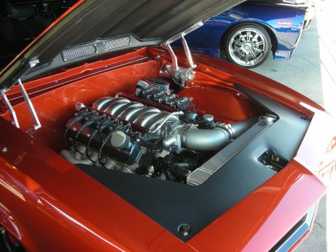 1998 Ford Crown Victoria - Custom V8 engine in an orange car's engine bay, with a blue car visible behind it.