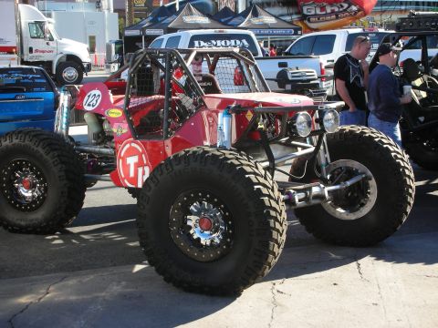 1998 Ford Crown Victoria - A custom-built red off-road buggy with oversized tires and a protective roll cage is displayed.