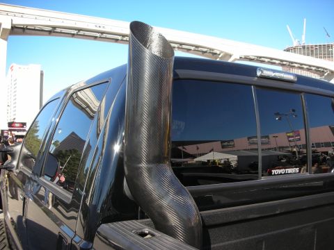 1998 Ford Crown Victoria - A black pickup truck features a prominent carbon fiber exhaust stack and a "TOYO TIRES" decal on the rear window.
