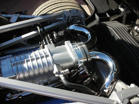 1998 Ford Crown Victoria - Close-up view of a supercharger and polished chrome piping, part of a vehicle's engine bay.