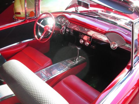1998 Ford Crown Victoria - The interior of a classic red 1955 Chevrolet Bel Air features bright red upholstery and chrome accents.
