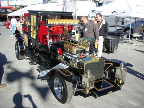 1998 Ford Crown Victoria - A highly customized hot rod with a unique dual engine setup is on display at an outdoor event.