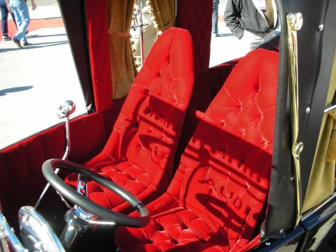 1998 Ford Crown Victoria - The interior of a custom vehicle features plush red velvet seats and a unique skull-shaped gear shift knob.