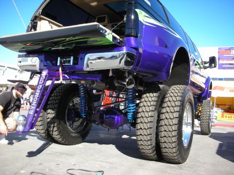 1998 Ford Crown Victoria - Custom purple dually truck with extensive modifications, including a lifted suspension and custom graphics, is displayed outdoors.