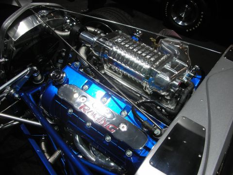 1998 Ford Crown Victoria - A highly customized V8 engine with a prominent supercharger and bright blue valve covers is displayed.