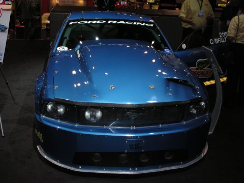 1998 Ford Crown Victoria - Customized blue Ford Mustang with racing modifications displayed indoors.