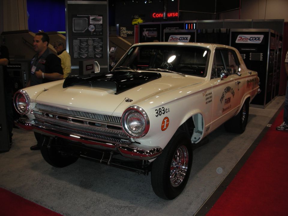 White drag car with black hood scoop and chrome wheels, text on door reads "THE FUNNY CAR FARM"