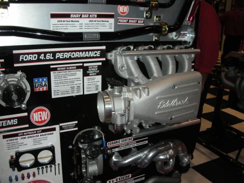 1998 Ford Crown Victoria - Display of Ford 4.6L performance parts, including intake elbows and throttle bodies.