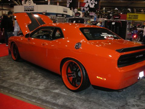 1998 Ford Crown Victoria - Custom orange Dodge Challenger on display at an indoor event with the hood open.