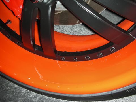 1998 Ford Crown Victoria - A custom wheel with an orange lip and black spokes is shown, with a red brake caliper visible behind it.